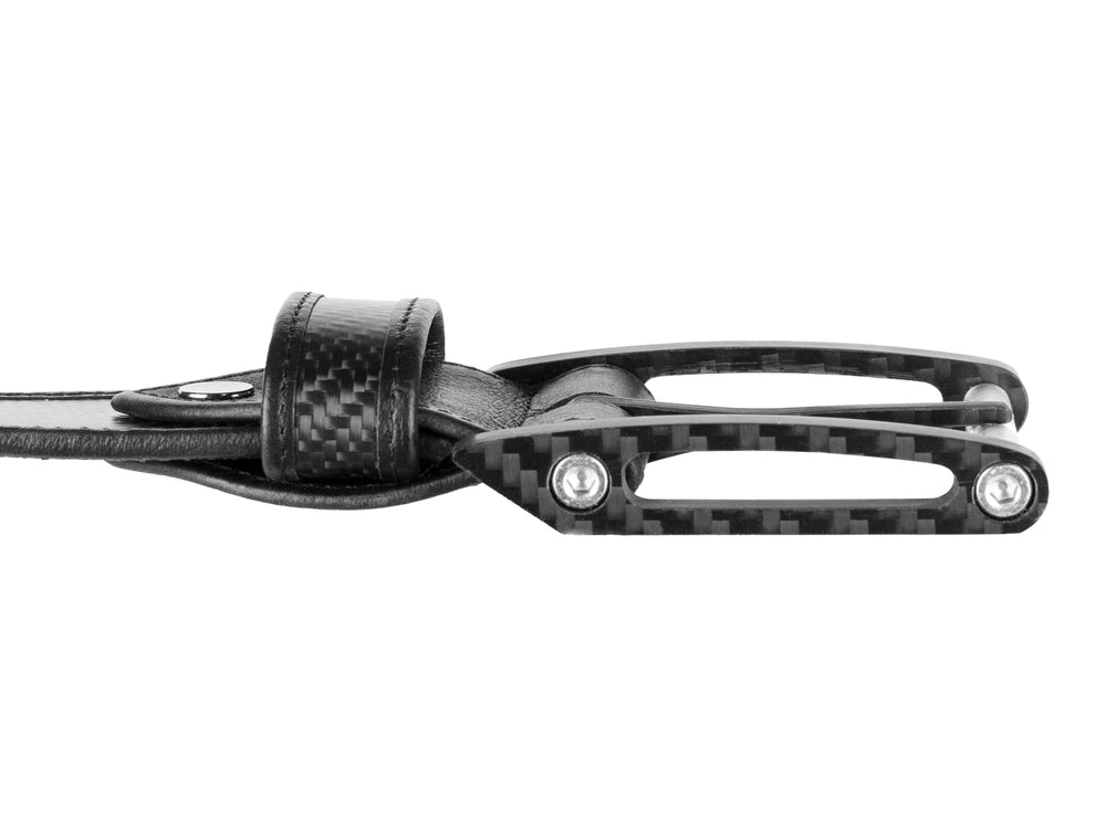 Close-up of carbon fiber belt buckle with leather accents, highlighting the CNC-milled solid carbon fiber construction.
