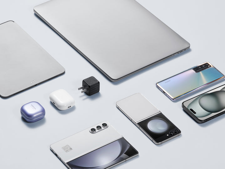 Assortment of modern tech gadgets with a carbon fiber textured GaN charger, showcasing compatibility and style.