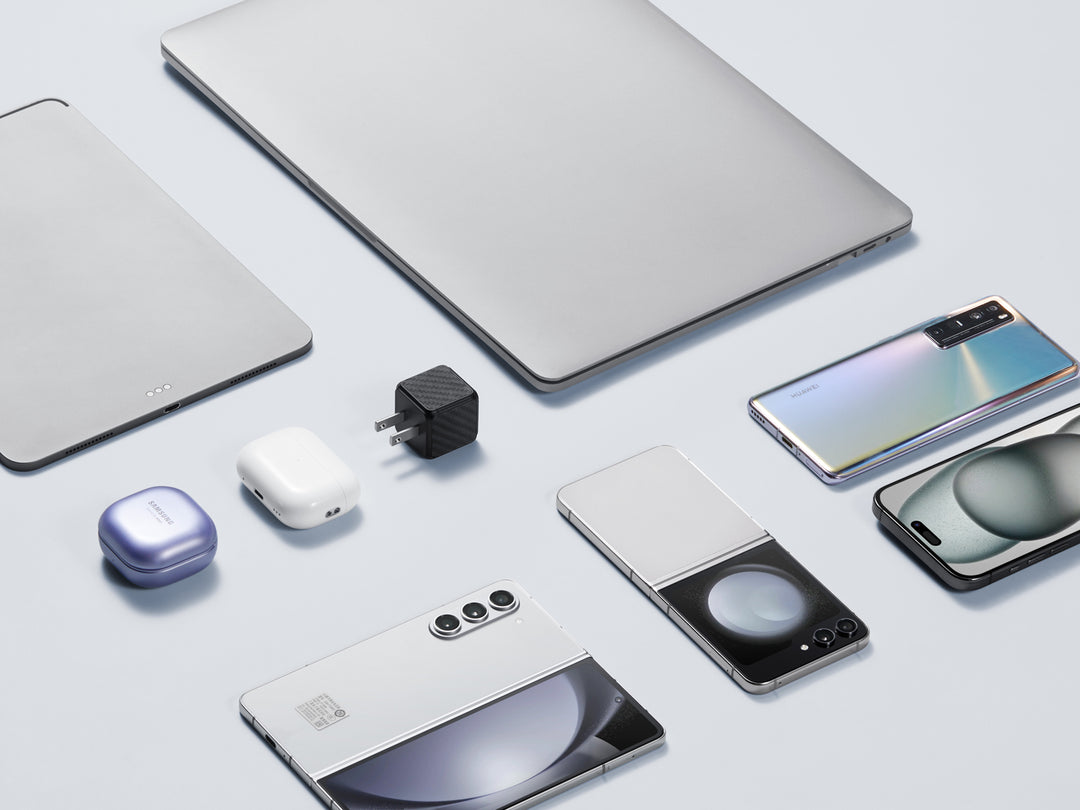 Assortment of modern tech gadgets with a carbon fiber textured GaN charger, showcasing compatibility and style.