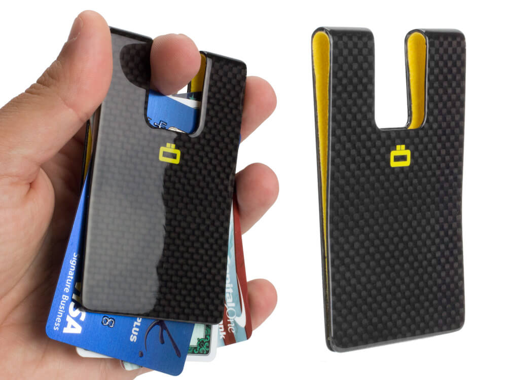 Close-up of a carbon fiber card clip in hand, showcasing its compact design and card-holding capacity.
