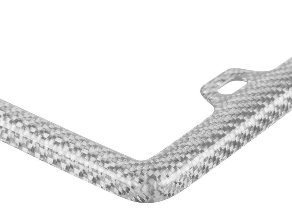 Close-up view of the corner of a silver fiberglass license plate frame with a twill weave pattern