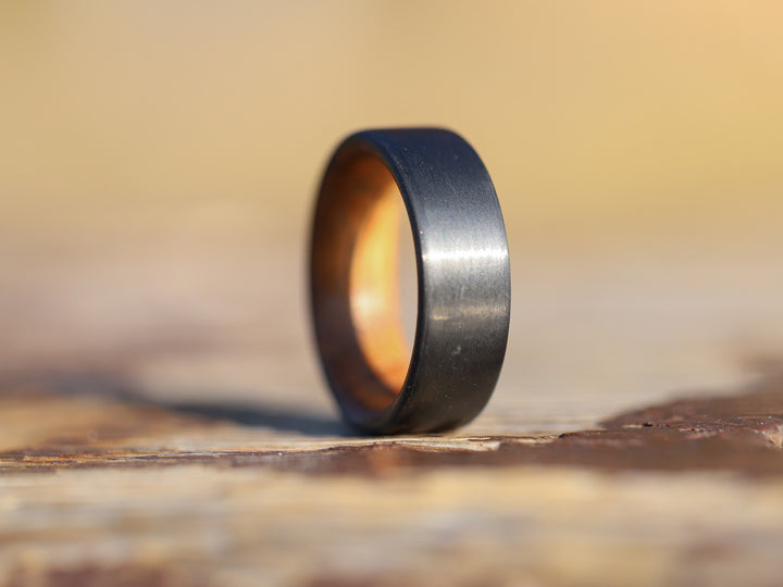 Cooper carbon fiber whiskey barrel ring on tree stump
