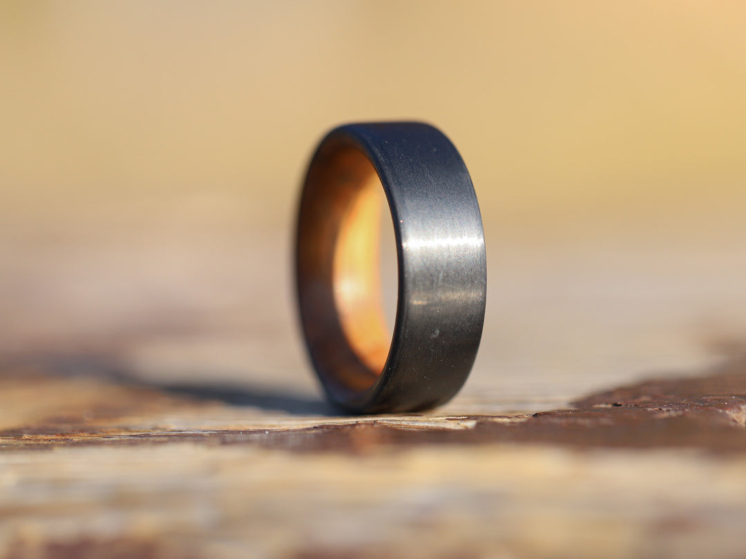 Cooper carbon fiber whiskey barrel ring on tree stump