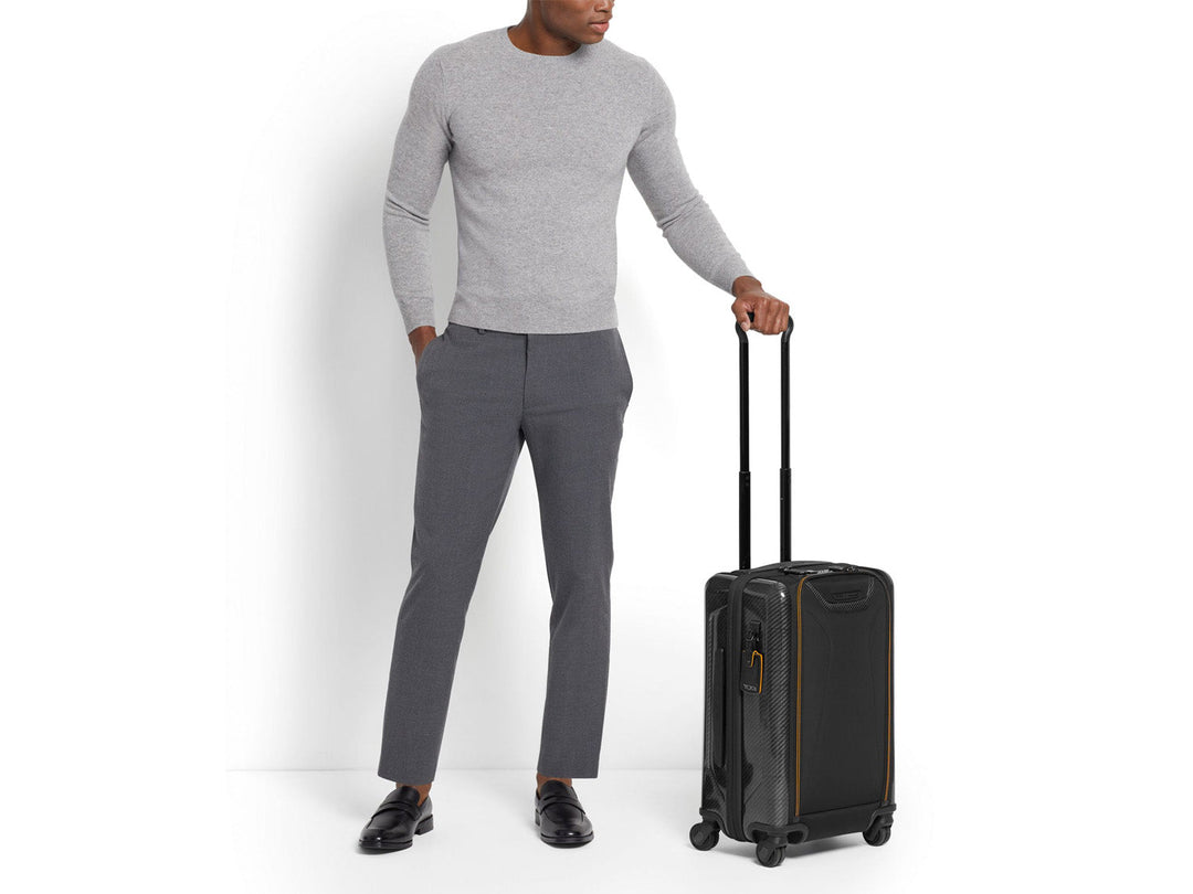 TUMI | McLaren Aero International Expandable 4 Wheel Carry-On being held#color_black-with-papaya